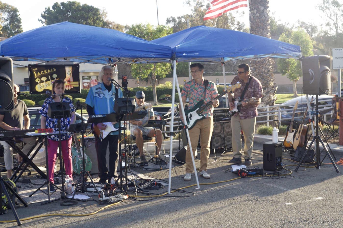 A live band, The Jackals, performing under a canopy tent at the festival.