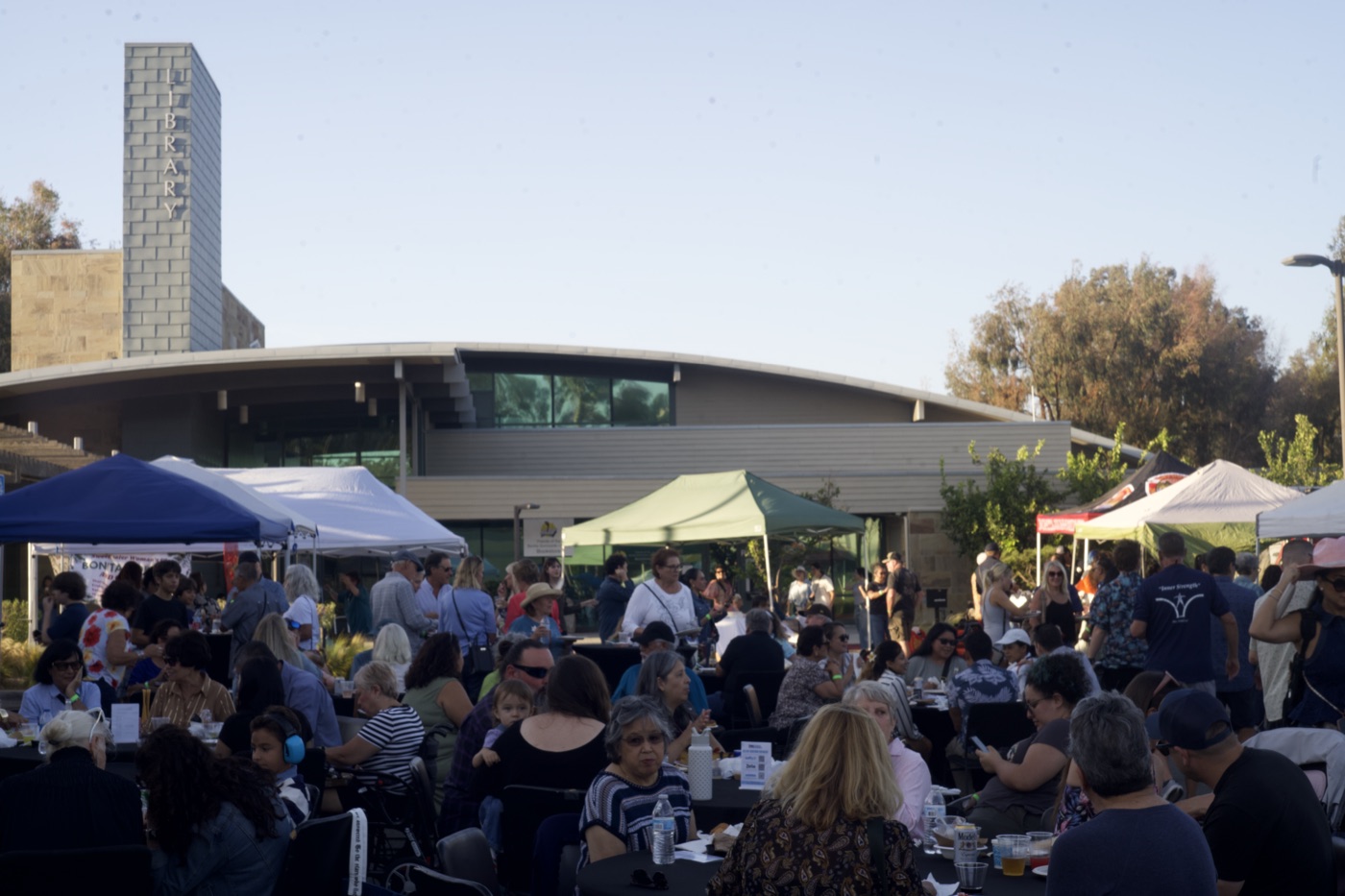 Another wide view of the festival crowd seated at tables.