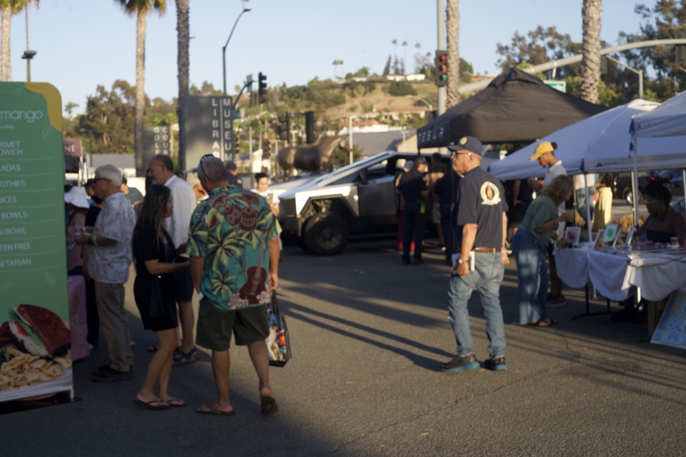 Festival-goers browsing vendor tents near the Bonita Museum's bronze horse statue.